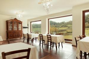 uma sala de jantar com mesas e cadeiras e um lustre em 'L Piasi em Cortanze
