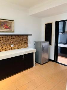 a kitchen with a stainless steel refrigerator in a room at Likas Square - KK Spacious Homestay in Kota Kinabalu