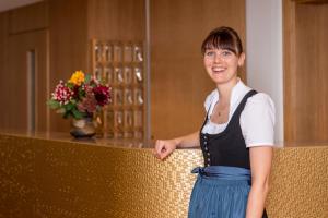 a woman standing next to a counter with flowers at Gasthaus-Pension Zum Kreuz in Stühlingen