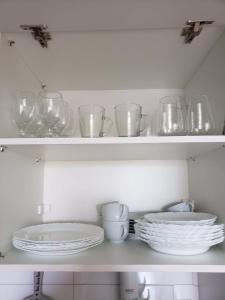 a shelf with plates and glasses and dishes on it at Excelente FLAT 2 QTS BESSA - FLAT ALTÂNTICO NORTE in João Pessoa