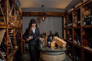 a woman standing in front of a wine cellar filled with bottles at Hotel Margherita in Praiano