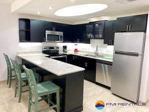 佩納斯科港的住宿－Linda Vista 106，厨房配有黑色橱柜和白色冰箱。