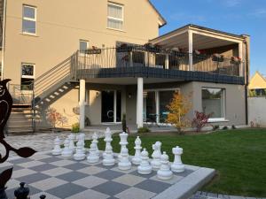 um tabuleiro de xadrez gigante em frente a uma casa em Maison d hotes Coeur de Village Alsace & spa em Rohrwiller