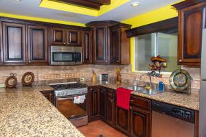 a kitchen with wooden cabinets and a sink at Bella Vista 7 in Puerto Peñasco