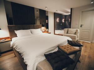 Hotel Romeo في كورتشي: غرفة نوم كبيرة مع سرير كبير وكرسي
