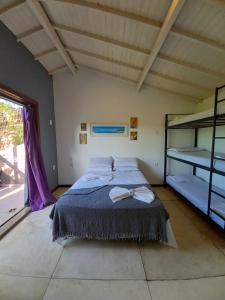 1 dormitorio con cama y ventana grande en El Misti Hostel & Suítes Buzios, en Búzios