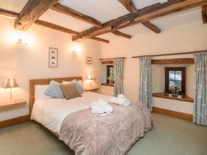 a bedroom with a large bed with towels on it at Riven Oak in Kendal