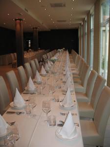 Gold Club Hotel & Casino في آيدوشتشينا: طاولة طويلة عليها كؤوس نبيذ ومناديل