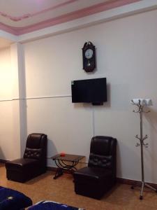 a room with two chairs and a clock on the wall at Hostel Khanh Hương 2 in Da Lat