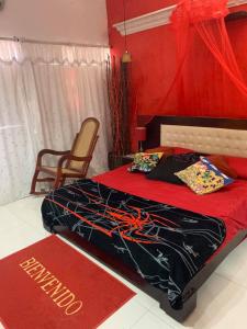 - une chambre avec un lit et un mur rouge dans l'établissement Apartamentos y Estudios Manga Real, à Carthagène des Indes