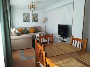 uma sala de estar com uma mesa e um sofá em Navarubia em Navacerrada