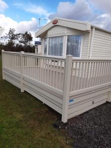 a house with a white picket fence at The Trailer By The Sea in Millom