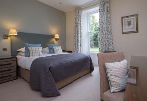a bedroom with a bed and a window and a chair at The Grasmere Hotel in Grasmere