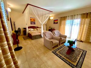- une chambre avec un lit, un canapé et une chaise dans l'établissement Hôtel La Belle Etoile & SPA, à Saly Portudal