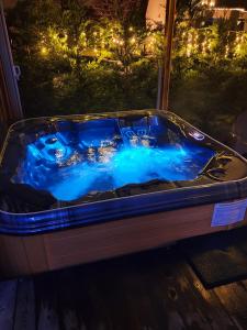 eine Whirlpool-Badewanne mit blauen Lichtern im Hof in der Unterkunft LE COTTAGE BARBIZONNAIS avec jacuzzi privé à partir de 10 ans in Barbizon