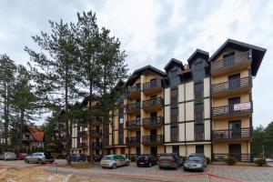 un edificio de apartamentos con coches aparcados en un aparcamiento en Apartman Nađa, en Zlatibor