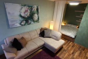 a living room with a white couch and a bedroom at Shokolade in Ventspils