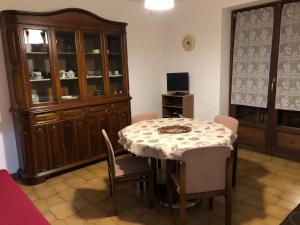 uma sala de jantar com mesa e cadeiras e um armário em Residenza Maria em Ala di Stura