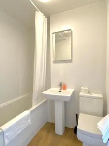 y baño con lavabo, aseo y espejo. en Studio in Stretford with Great Transport Links, en Mánchester