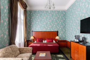 a hotel room with a bed and a couch at Grandhotel Pupp in Karlovy Vary