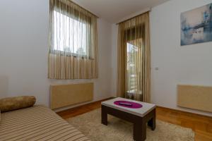 ein Wohnzimmer mit einem Sofa und einem Tisch in der Unterkunft Apartman Nex in Zlatibor