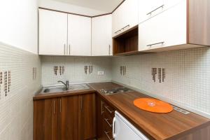 eine Küche mit weißen Schränken und einer orangefarbenen Platte auf der Theke in der Unterkunft Apartman Nex in Zlatibor