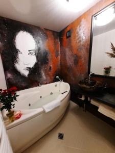 a bathroom with a painting on the wall and a bath tub at Amrai in Ventspils