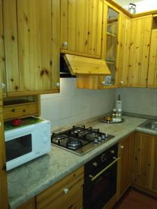 een keuken met houten kasten en een fornuis met oven bij LA CASA DI PUFFY in Selvino
