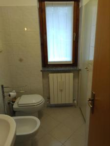 een kleine badkamer met een toilet en een raam bij LA CASA DI PUFFY in Selvino