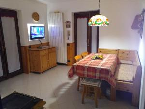 a dining room with a table and a television at LA CASA DI PUFFY in Selvino