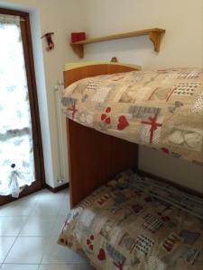 een slaapkamer met een stapelbed en een raam bij LA CASA DI PUFFY in Selvino