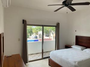 a bedroom with a bed and a ceiling fan at Posada Malix Pek in Tulum