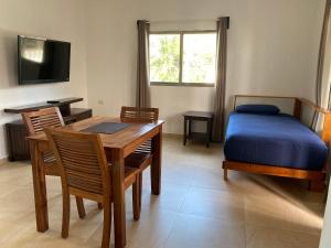 Un dormitorio con una cama y una mesa y sillas. en Posada Malix Pek, en Tulum