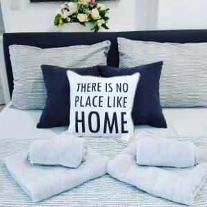 a bed with a pillow that says there is no place like home at Apartments Novakovic in Zlatibor