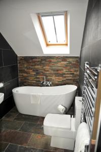 uma casa de banho com banheira e WC em The Tal-Y-Cafn Hotel em Tal-y-Cafn