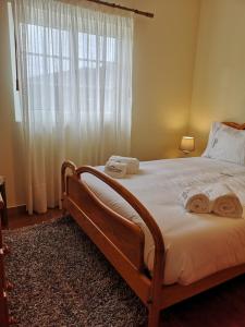 Un dormitorio con una cama grande con toallas. en Casa de Bouças, en São Pedro