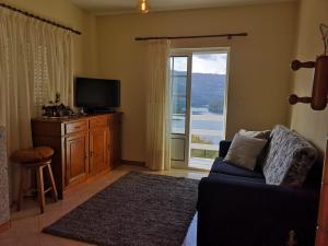 a living room with a couch and a tv and a window at Casa de Bouças in São Pedro