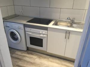 a kitchen with a sink and a stove and a washing machine at Cala Serena Beach 4 in Felanitx