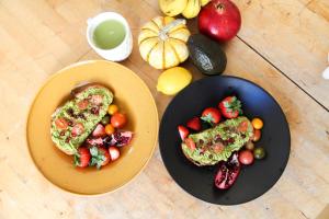 a table with two plates of food and a plate of vegetables at Ocean Front Vortex Female Hostel private rooms Free bikes in Los Angeles