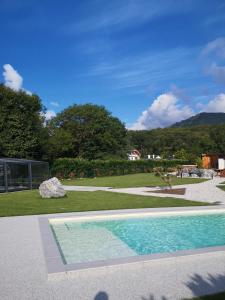 a swimming pool in a yard with a rock at L'Argalyde Esprit Pyrénées Wellness & Cycling in Ayzac-Ost