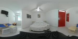 a white room with a table and a red door at Urbano Suítes in Ubatuba