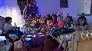 un grupo de niños sentados alrededor de un árbol de Navidad en Hotel Casa del Marquez de Bahichala, en Barichara
