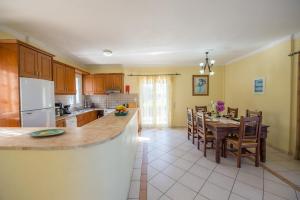 a kitchen and dining room with a table and chairs at Villa Lenio Perithia Loutses in Perítheia