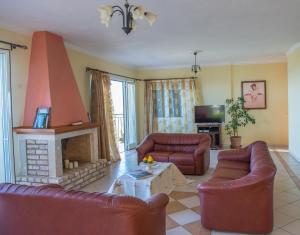 a living room with two couches and a fireplace at Villa Lenio Perithia Loutses in Perítheia