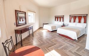 Habitación de hotel con 2 camas y espejo en Hotel Alcazar - Guadalajara Centro Historico en Guadalajara