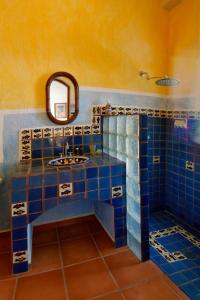 a bathroom with blue tiles and a mirror and a sink at Ventana Bay Resort in La Ventana