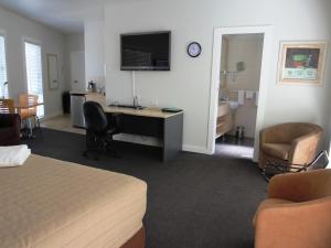 a hotel room with a bed and a desk with a computer at Aston Hill Motor Lodge in Port Macquarie