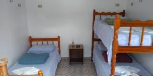 a bedroom with two bunk beds and a table at Pousada São Francisco in Morretes