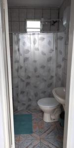 a bathroom with a toilet and a shower curtain at Pousada São Francisco in Morretes