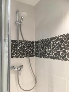 a shower in a bathroom with black and white tile at Résidence Dome de Polset - Studio 2 adultes et 2 enfants - Wifi in Val Thorens